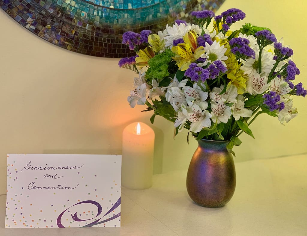 Celebrating with a beautiful bouquet of flowers, a candle and a card, Toni Gattone Resilient Gardener speaker and author blogs about her Intentions for 2020: Graciousness and Connection. 