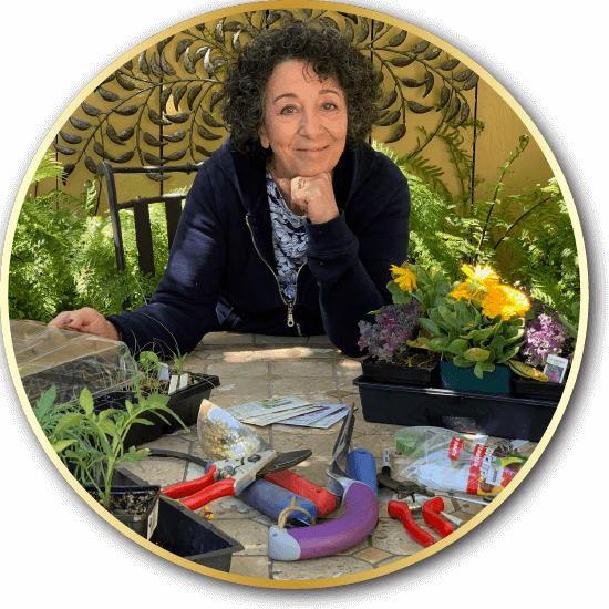 Speaker Toni Gattone seated in her garden and surrounded by tools