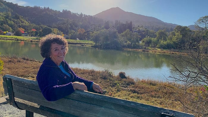 Author and master gardener Toni Gattone sitting lakeside